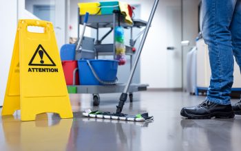 Worker janitor Mopping Floor In Office with trolley